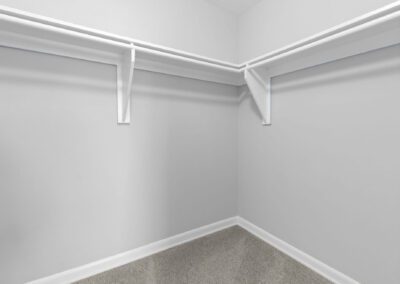 A white closet with a matching door, set against pristine white walls, creating a clean and minimalist aesthetic